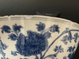 a blue and white bowl with a flower design on it