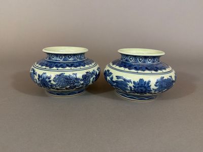two blue and white vases sitting on top of a table