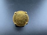 a close up of a gold coin on a black surface