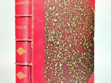 un vieux livre rouge orné de dorures, posé sur une surface blanche