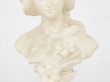 un buste en marbre blanc représentant une femme tenant des fleurs