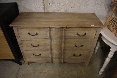 une photo représentant une commode à tiroirs et une chaise dans une pièce