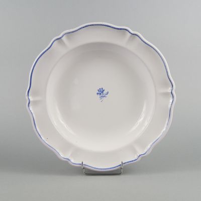 a blue and white plate with a flower design on the rim