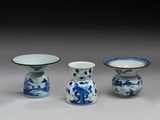 trois vases bleus et blancs et un bol posés sur une table