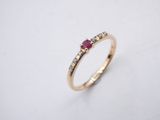 a yellow gold ring with a ruby stone and white diamonds
