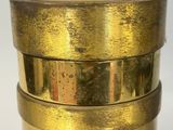 a gold vase with a gold handle on a white table