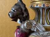 a large vase with a cat on top of it