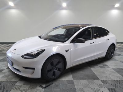 the white tesla model 3 is parked in a clean room