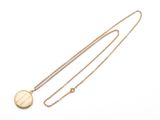 gros plan d'un collier en or sur fond blanc
