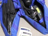 un sac de voyage bleu posé par terre, contenant des affaires