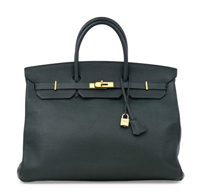 un sac à main en cuir noir muni d'un fermoir doré sur la poignée