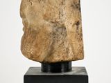 an image of a stone head on a black stand