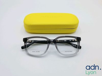 the glasses are next to a yellow case on a white surface