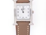 gros plan d'une montre sur une surface blanche avec un bracelet marron