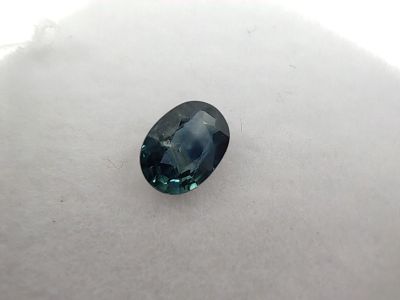 an oval blue sapphire stone on a white surface