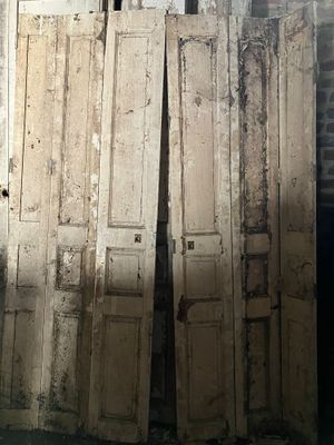 de nombreuses vieilles portes appuyées contre le mur