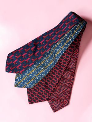 three different colored ties on a pink background