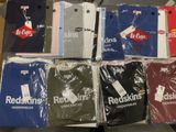 un grand nombre de t-shirts posés sur une table