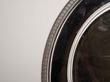 a silver plate with a silver rim on a table