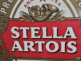 stella artois beer sign hanging on the side of a building