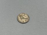 une petite pièce d'argent sur laquelle figure le portrait d'une femme