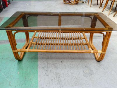 une table basse avec un plateau en verre, posée à même le sol