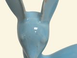 a small blue rabbit figurine sitting on top of a table