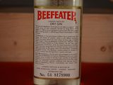 a bottle of beefeater dry gin on a red table