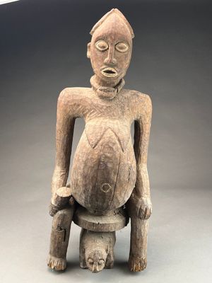 statue représentant un homme assis sur un tabouret, les mains sur les hanches