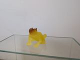 un animal en plastique jaune posé sur une table en verre