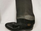 pair of black leather boots with gold buckles on a white background