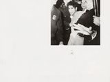 black and white photograph of a group of men standing around a woman