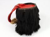 a close up of a black furry bag with a red handle