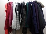 clothes hanging on a rack in a room with white walls
