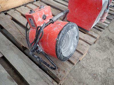 two red blowers sitting on a pallet next to each other
