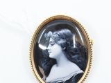 an antique photo of a woman in a black and white dress in a gold frame