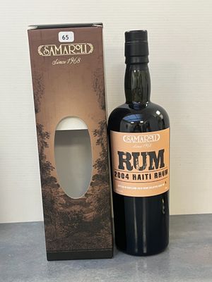 une bouteille de rhum posée à côté d'une boîte sur une table