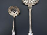 two spoons and a spoon rest on a black surface