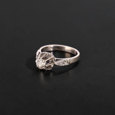a close up of a diamond ring on a black surface