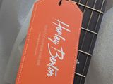 a guitar with a thank tag attached to it ' s neck