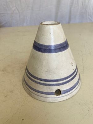 un vase blanc et bleu posé sur une table, sur fond blanc