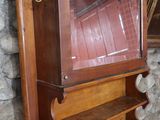 une étagère en bois surmontée d'un miroir, à côté d'un lavabo