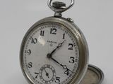 a silver pocket watch sitting on top of a white table