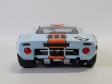 the blue and orange model of a race car on a white surface