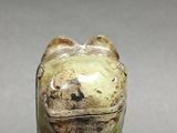 a small statue of a dog with a glass on it ' s head