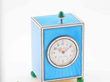 a small blue clock sitting next to a pair of scissors