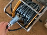 a hand holding a hose that is attached to a reel