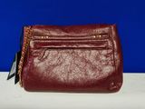 the red purse is sitting on a white table