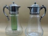 deux vases en verre munis de couvercles en argent et contenant un liquide vert