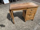a wooden desk with drawers and a mirror in the background